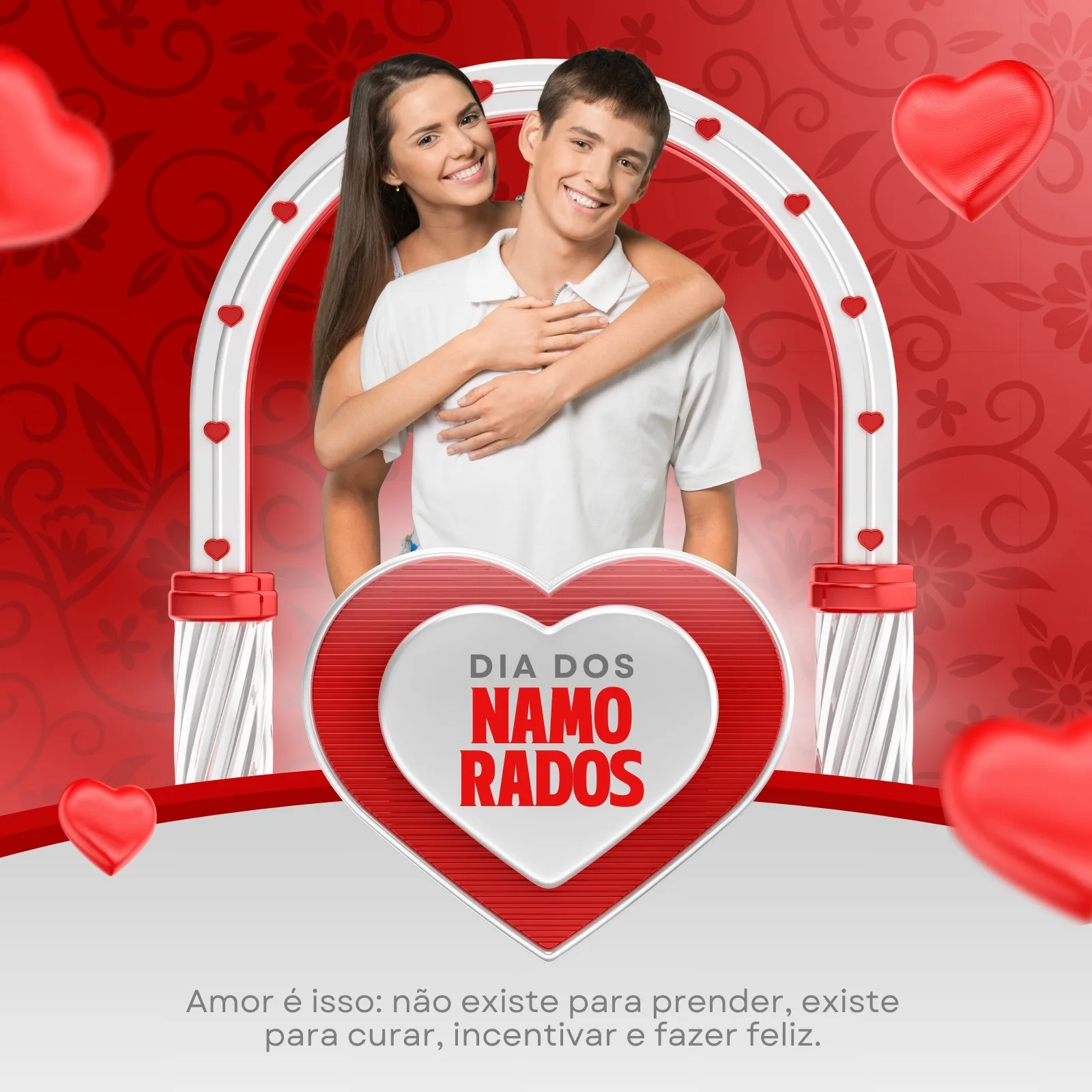 Casal sorrindo e abraçado, com a mulher atrás do homem, em um design com tema de Dia dos Namorados. Cores predominantes vermelho e cinza, com corações e um arco decorativo. Perfeito para posts de redes sociais.