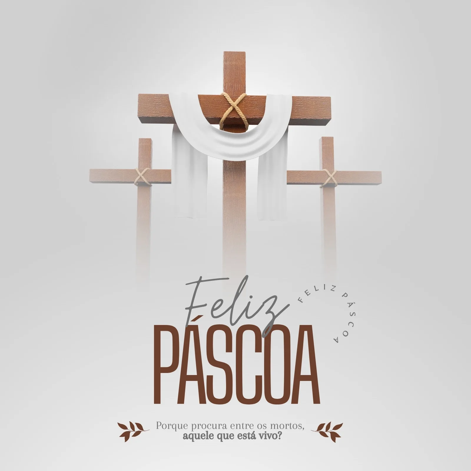 Um post minimalista para redes sociais com as três cruzes da crucificação em tons de madeira marrom. A cruz central está coberta por um pano branco amarrado com corda. Abaixo, a frase 'Feliz Páscoa' em tipografia elegante, seguida por uma citação bíblica sobre a ressurreição.